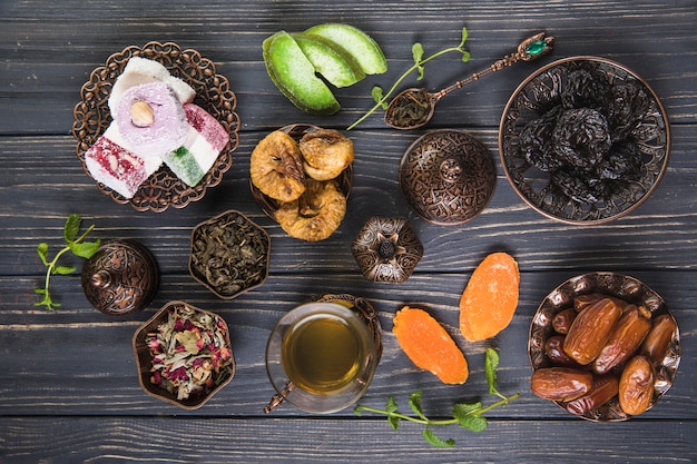 Vaso de té con diferentes frutas secas en mesa de madera