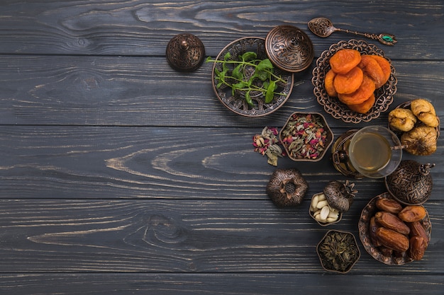 Vaso de té con diferentes frutas secas en mesa