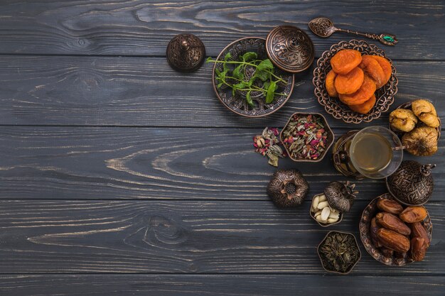 Vaso de té con diferentes frutas secas en mesa