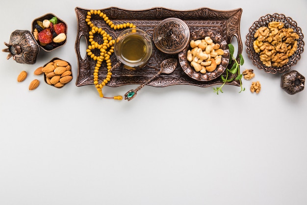 Foto gratuita vaso de té con diferentes frutos secos y cuentas.