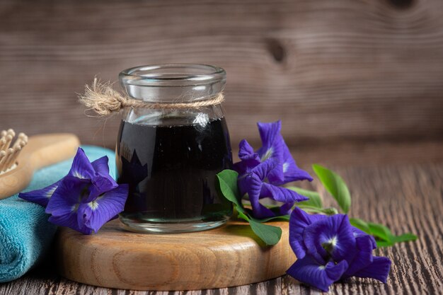 Vaso de té de flor de guisante de mariposa puesto en bandeja de madera