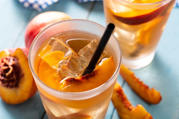 Vaso de té de melocotón con cubitos de hielo