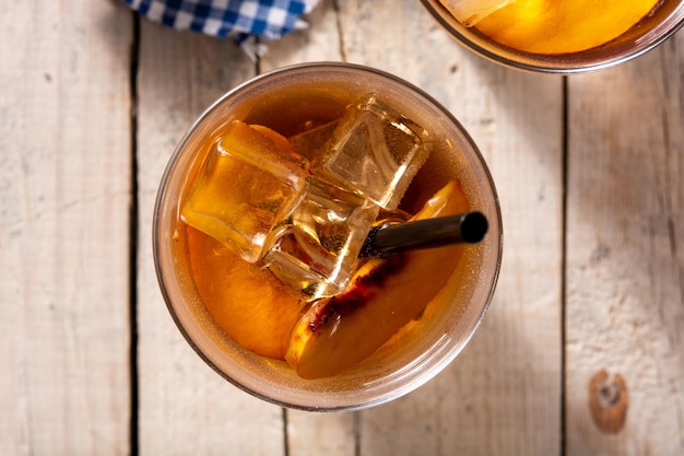 Vaso de té de melocotón con cubitos de hielo