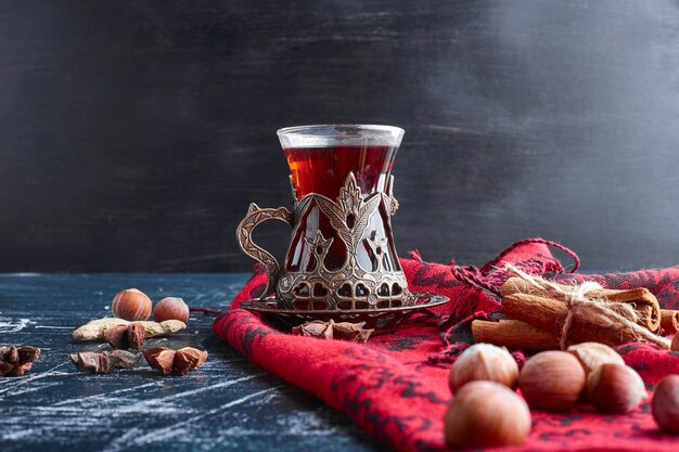 Un vaso de té con nueces y canela.