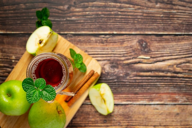 Vaso de té saludable de manzana verde junto a manzanas verdes frescas