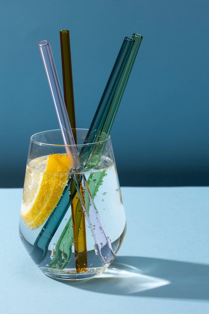 Foto gratuita vaso transparente con agua con gas y pajitas de cristal de colores