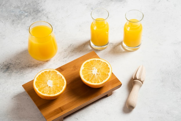 Un vaso de vasos de jugo fresco con rodajas de naranja.