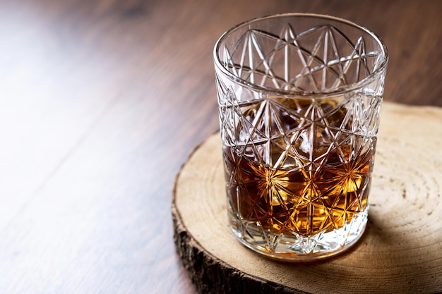 Vaso de whisky escocés en mesa de madera