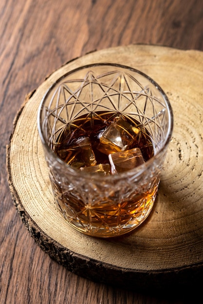 Vaso de whisky escocés en mesa de madera