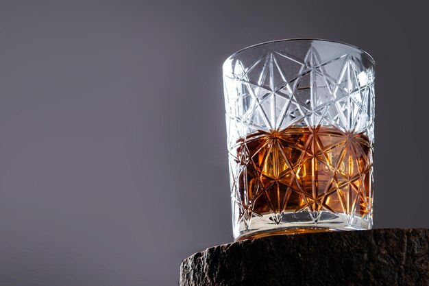 Vaso de whisky escocés sobre fondo gris