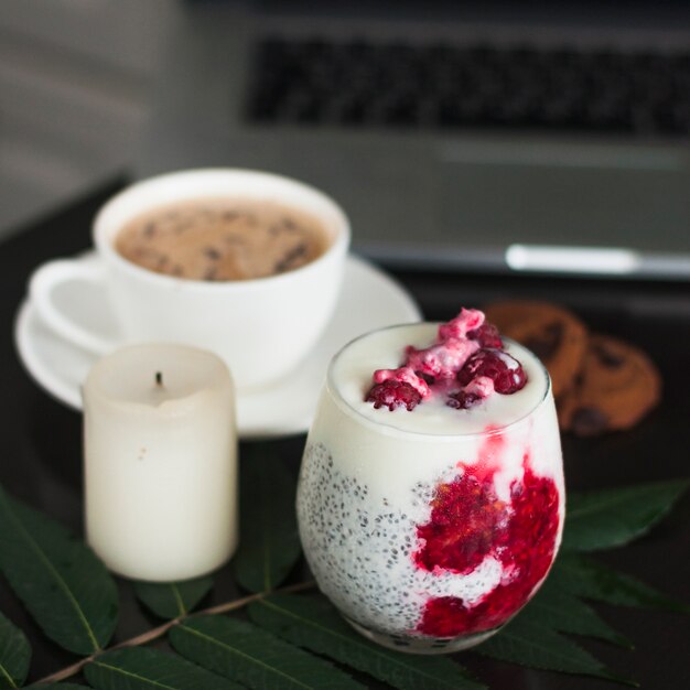 Vaso de yogur con semillas de chia y frambuesas frescas en la hoja