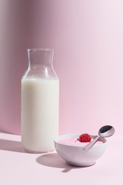 Vaso con yougurt con frambuesa en el escritorio