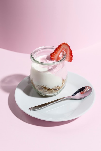 Foto gratuita vaso con yougurt con frambuesa en la mesa