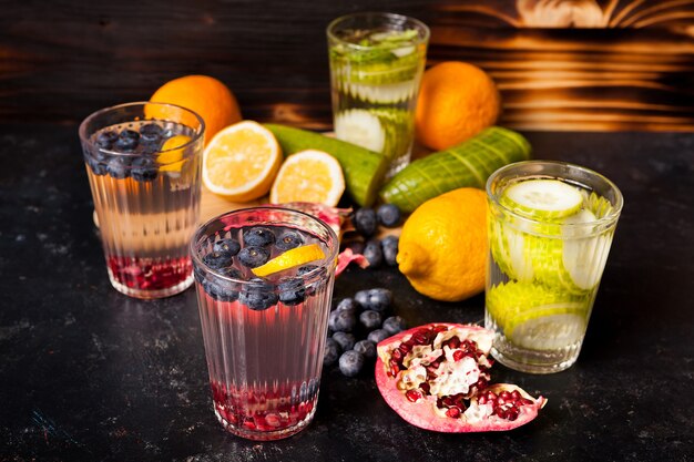 Vasos con agua de desintoxicación orgánica fresca natural sobre fondo vintage de madera oscura