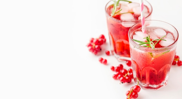 Foto gratuita vasos de alto ángulo de vodka de arándano con hielo y espacio de copia