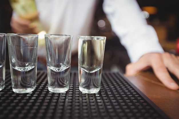 Vasos de chupito vacíos en barra de bar