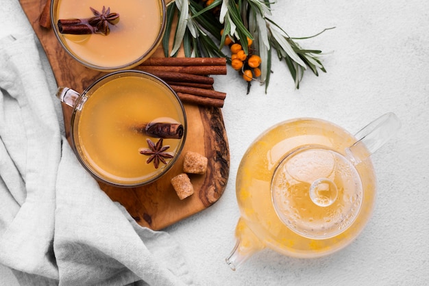 Vasos con jugo de frutas con sabor y canela en la mesa