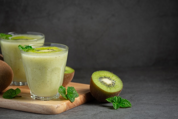 Foto gratuita vasos de jugo de kiwi en tabla de cortar de madera