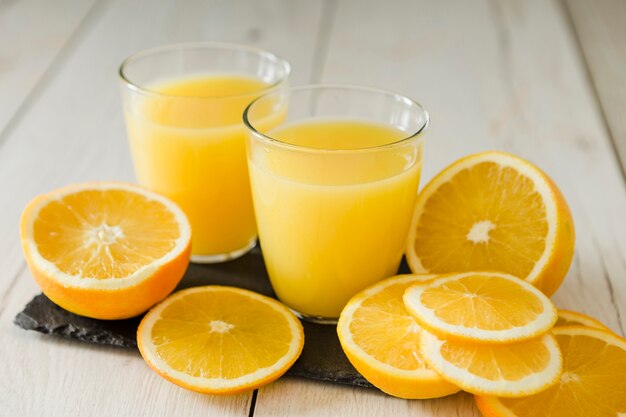 Vasos de jugo de naranja en pizarra