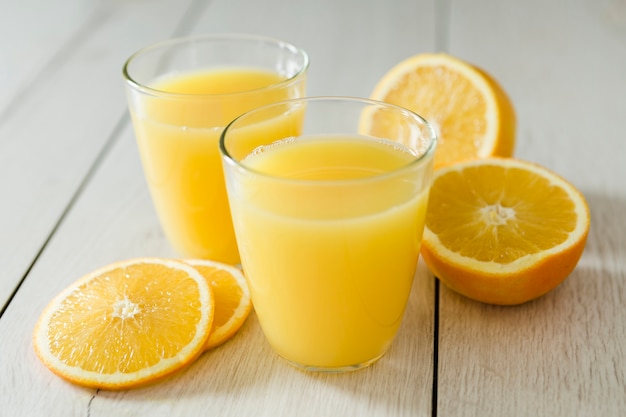 Vasos de jugo de naranja con rodajas de fruta.