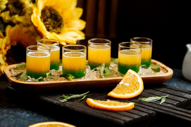 Vasos de jugo de ombre con menta y naranja