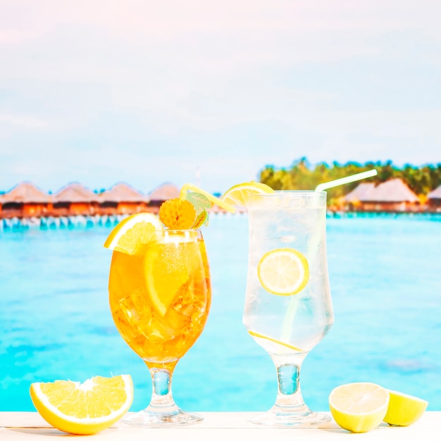 Foto gratuita vasos de jugosas bebidas de naranja limón con paja y cítricos en rodajas