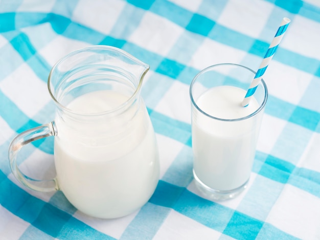 Vasos de leche con pajita y jarra