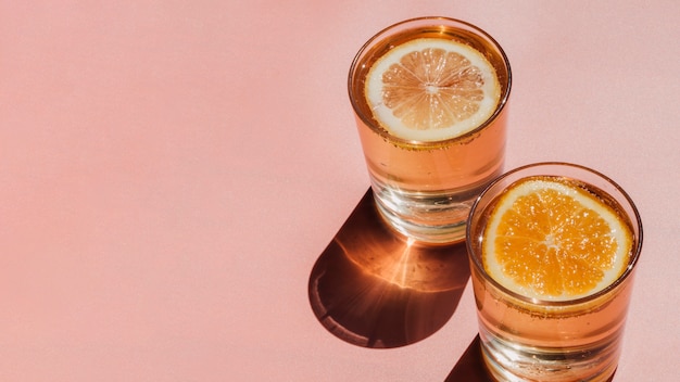 Foto gratuita vasos llenos de agua y rodajas de naranja y espacio de copia