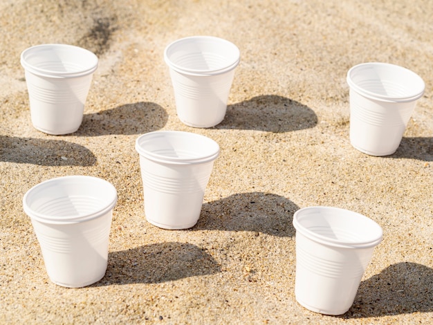 Vasos de plástico en la arena de la playa