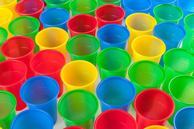 Vasos de plástico multicolor aislado sobre fondo blanco.