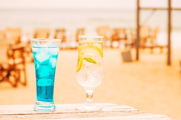 Vasos de refrescos de menta azul en mesa de madera