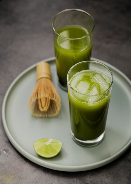 Vasos de té matcha con cubitos de hielo y lima