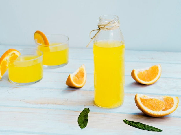 Vasos de zumo de naranja con fruta y menta.