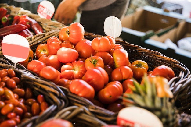 Vegetal orgánico saludable en canasta de mimbre con etiqueta de precio en puesto de mercado