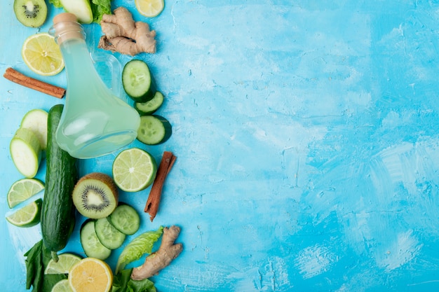 Foto gratuita vegetales verdes y jugo de limón en azul