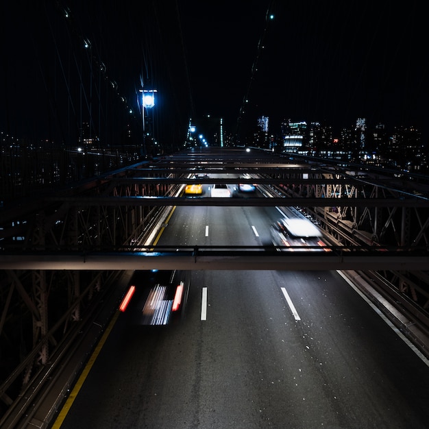 Vehículos en el puente por la noche con movimiento borroso
