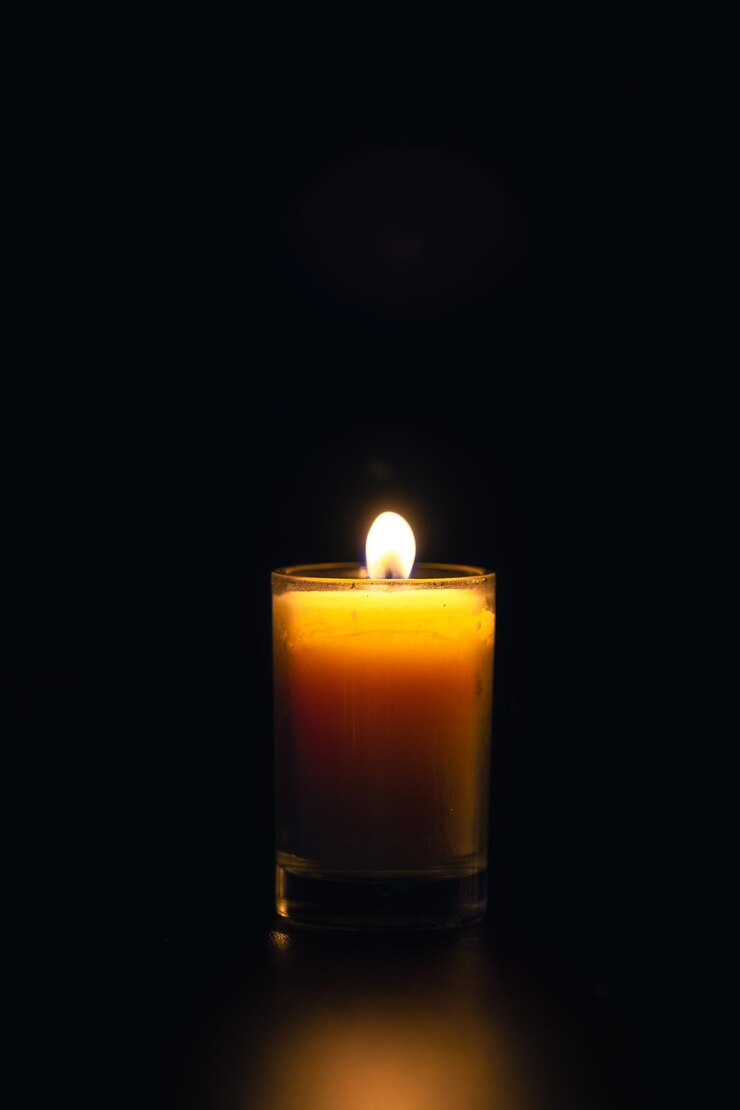 Foto gratuito vela encendida sobre fondo negro con luz de fondo día de la memoria