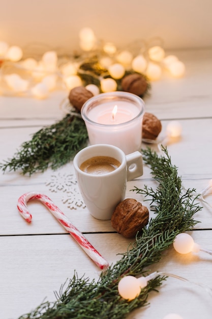 Vela encendida con taza y nueces