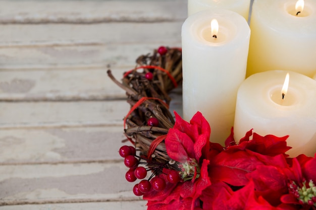 Velas blancas encendidas con flores rojas