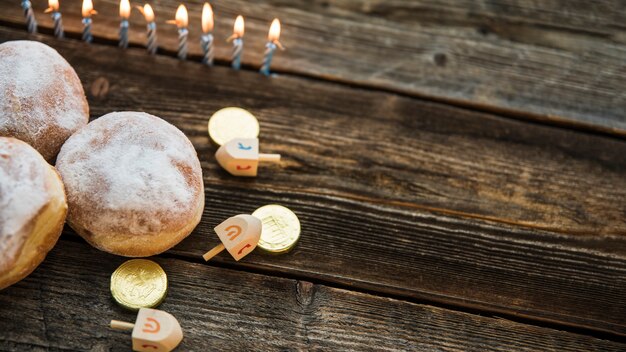 Velas cerca de donuts y símbolos de Hanukkah