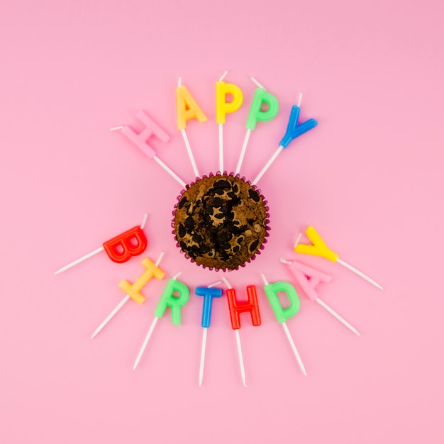 Foto gratuita velas de colores alrededor de deliciosos muffins