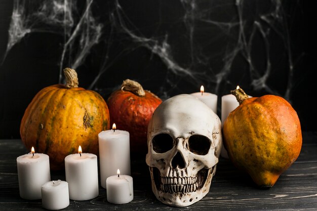 Velas encendidas con calabazas y calavera