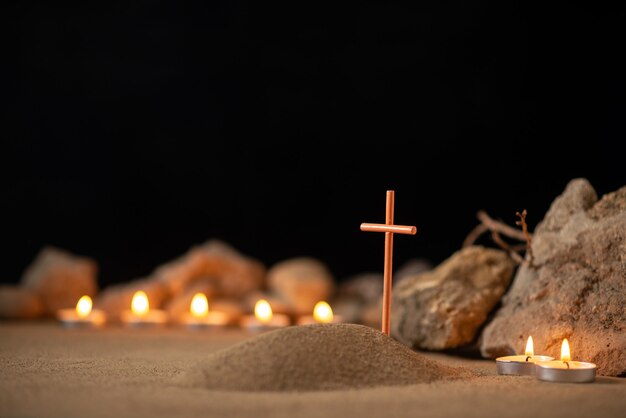 Velas encendidas con piedras alrededor de la pequeña tumba como recuerdo del funeral de la muerte