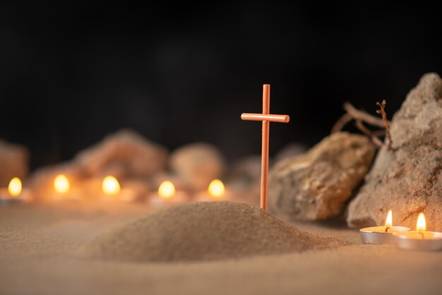 Velas encendidas con piedras alrededor de la pequeña tumba como recuerdo de la muerte del funeral