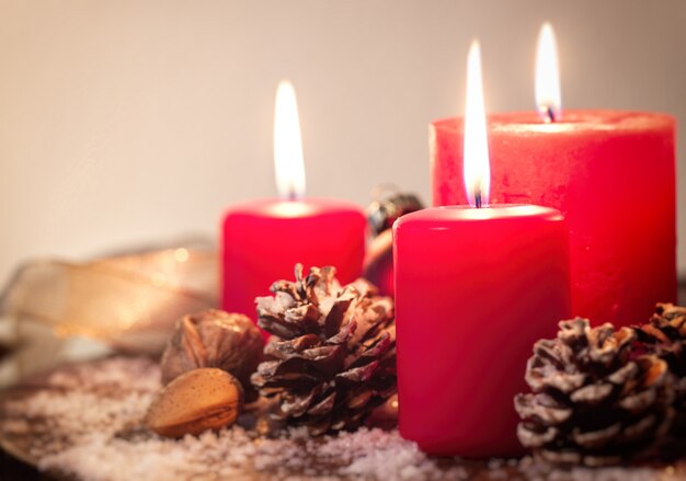 Velas navideñas rojas con piñas de abeto