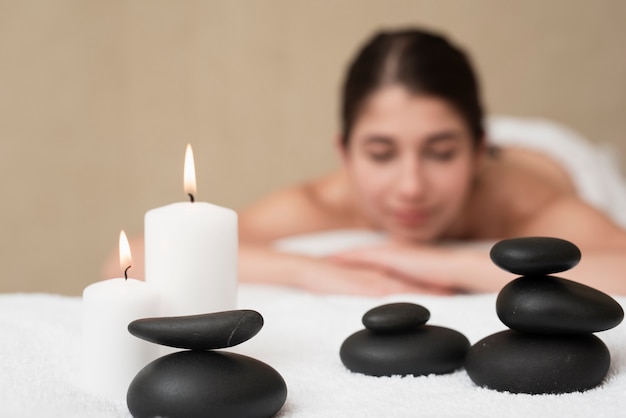 Velas y rocas de spa con mujer en spa