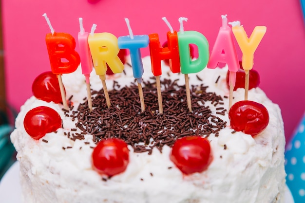 Velas de texto de cumpleaños colorido en pastel blanco