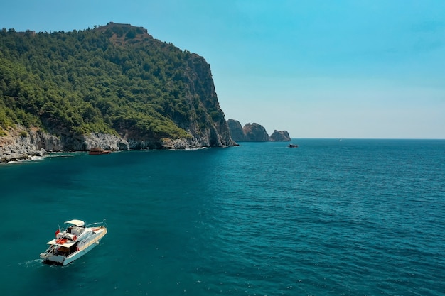 Foto gratuita velero en el mar en la luz del sol de la tarde sobre hermosas montañas grandes, aventura de verano de lujo, vacaciones activas en el mar mediterráneo, turquía