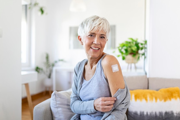 Vendaje adhesivo en el brazo después de la inyección de la vacuna o el medicamento VENDAJES ADHESIVOS YESO Medical EquipmentSoft focus Vendaje adhesivo en un braquio femenino después de la vacunación covid19