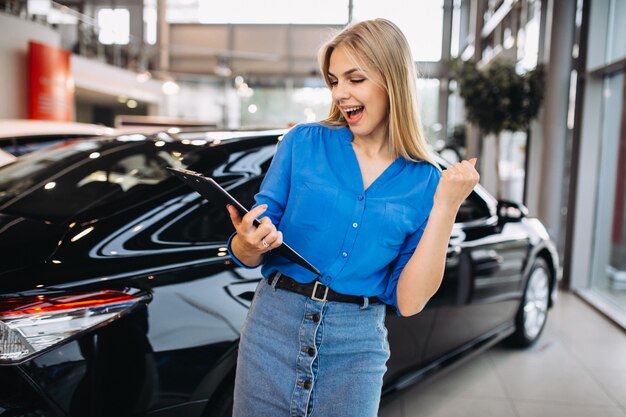 Vendedor femenino en una sala de exposición de automóviles